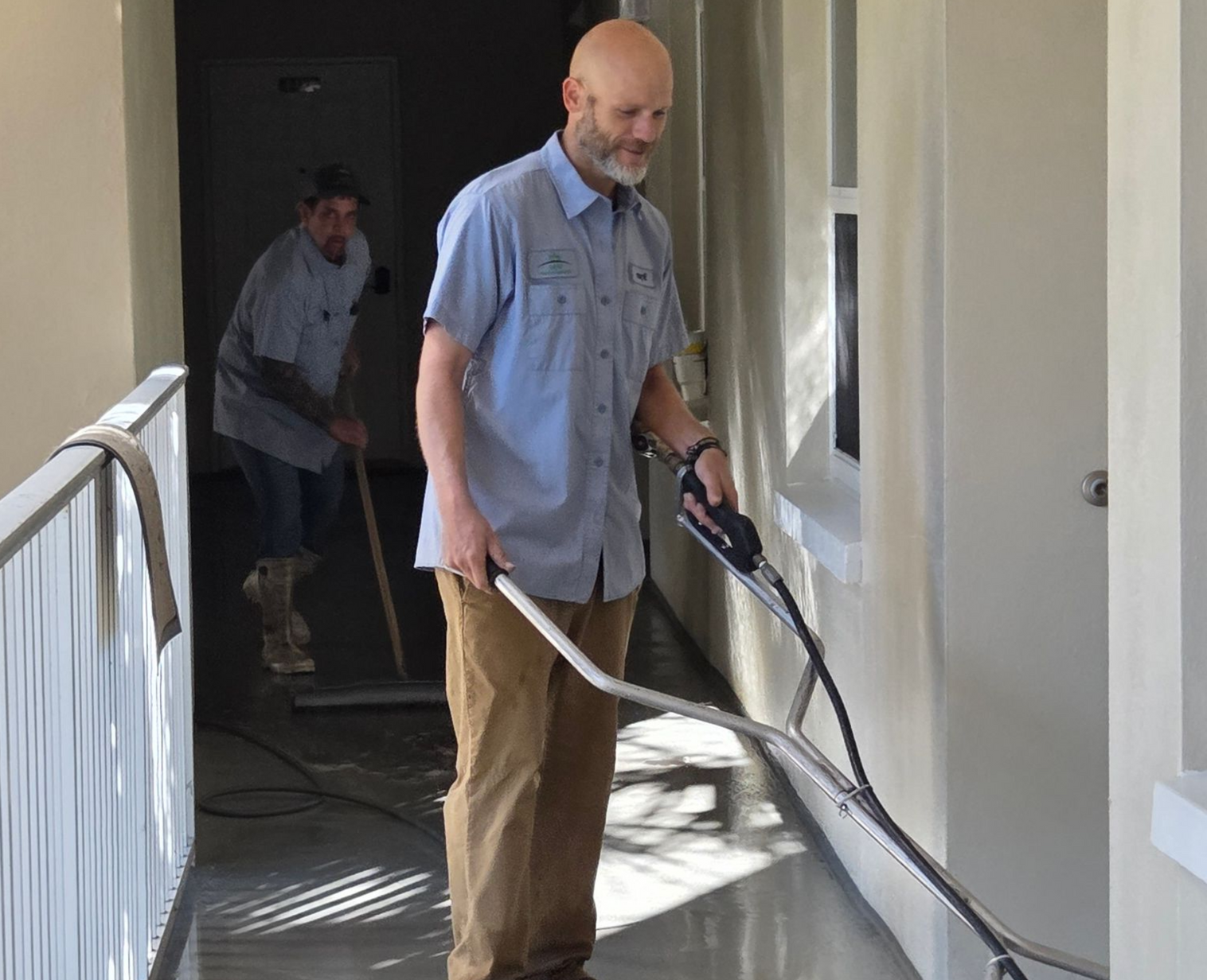 A woman is cleaning the floor with a vacuum cleaner.
