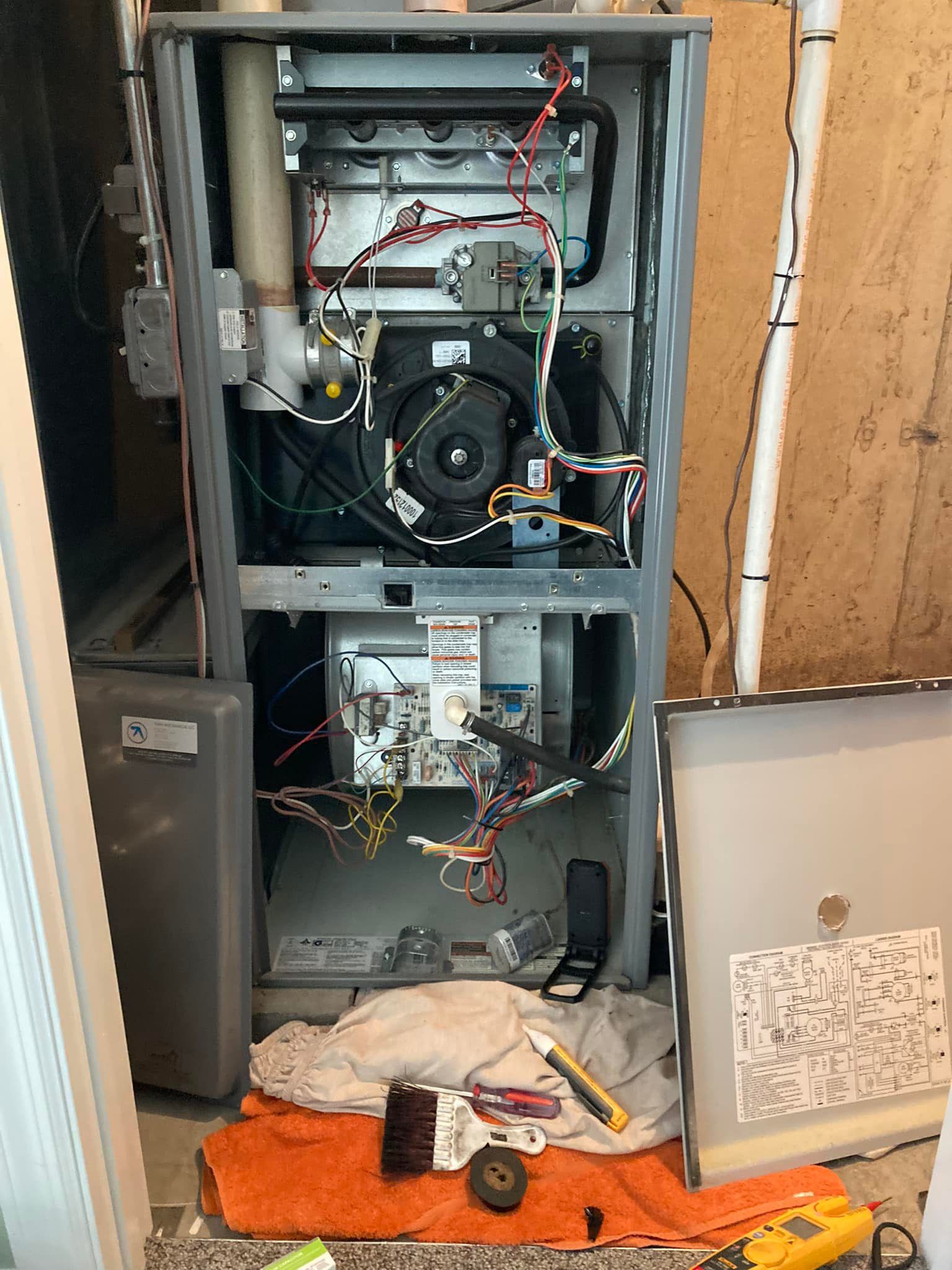 A heating system is being repaired in a basement.
