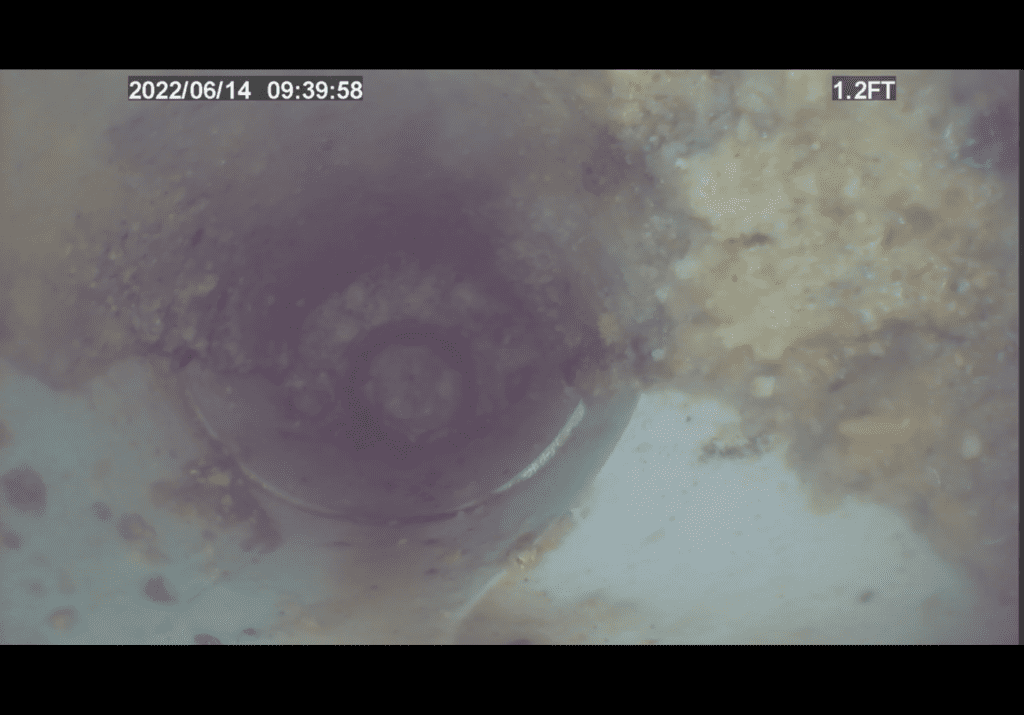 A camera is taking a picture of a hole in the ground.