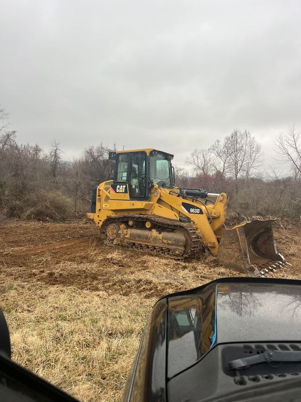 A bulldozer is moving dirt in a field.