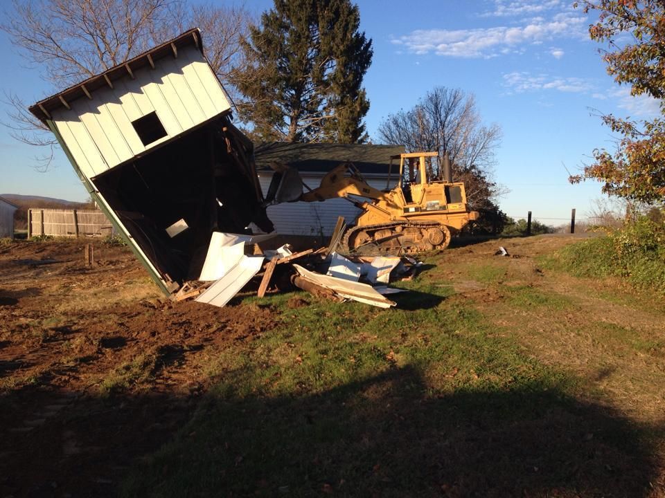 A house is being demolished by a bulldozer