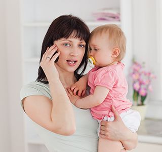 Mom on the phone with a baby in her arms