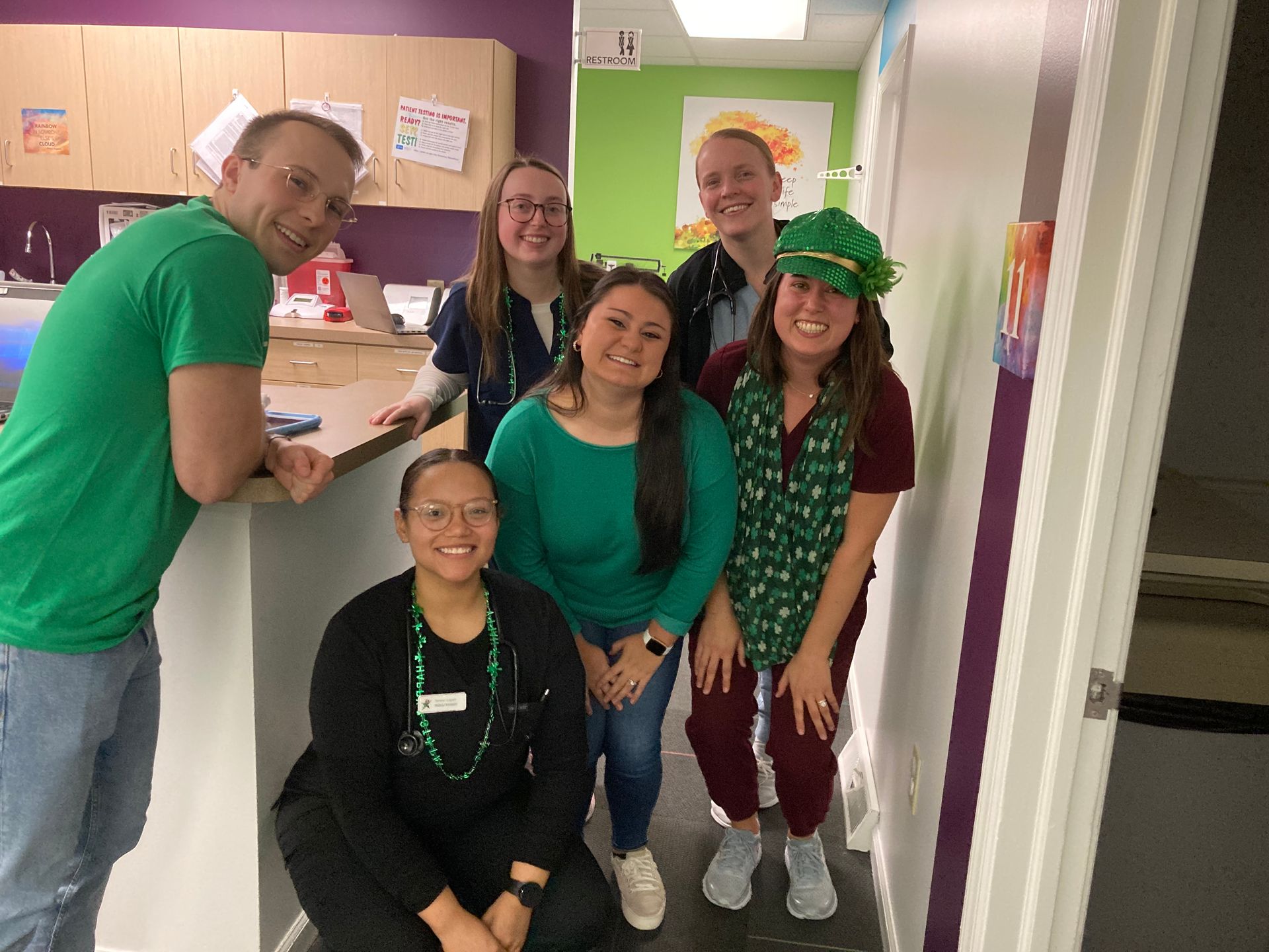 A group of people are posing for a picture in a kitchen.