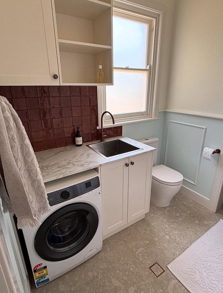 Laundry Room With Washing Machine, Sink, Toilet, and Cabinetry — JAJ Plumbing in Mount Austin, NSW