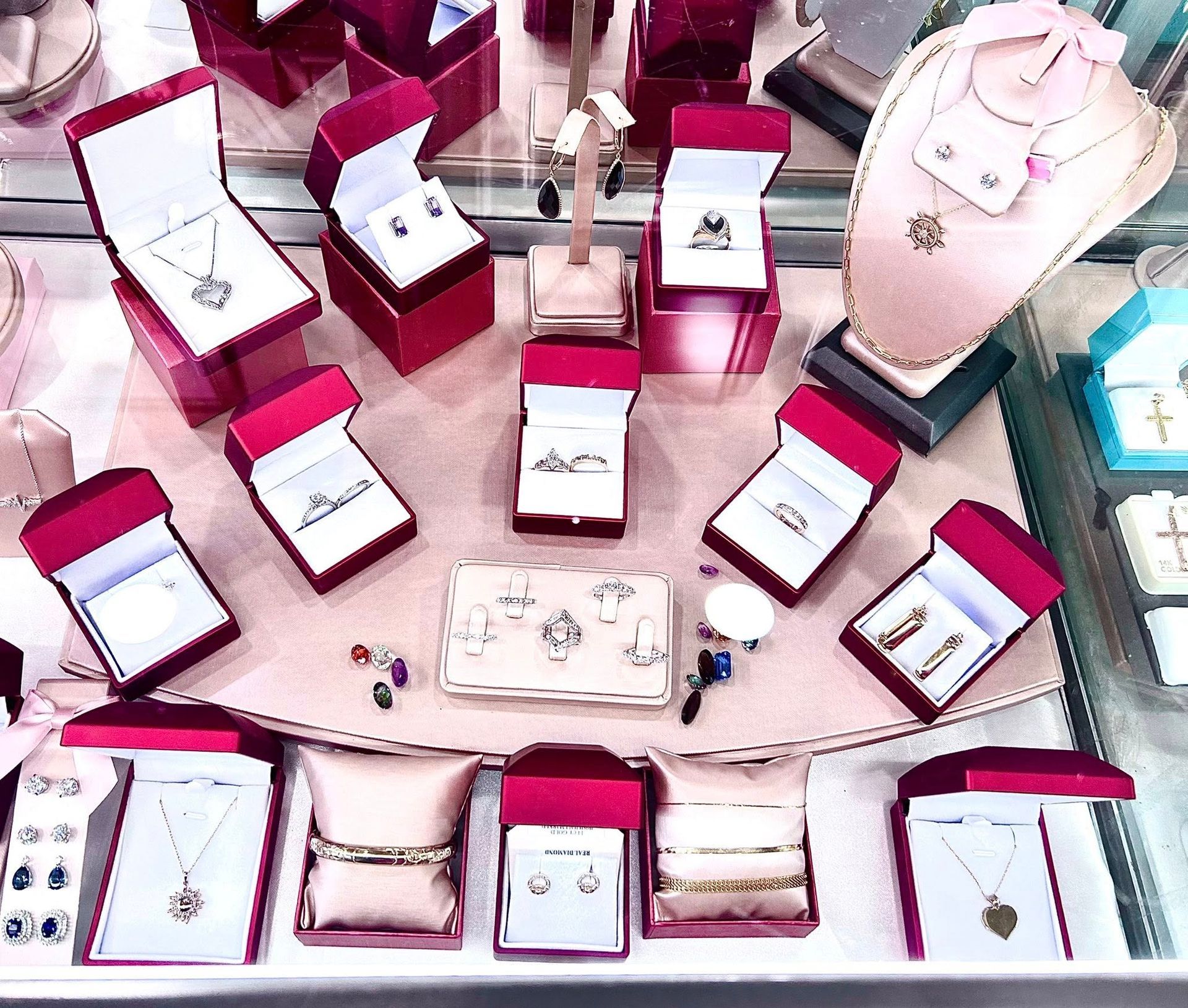 Jewelry display with necklaces, earrings, and rings in red boxes.