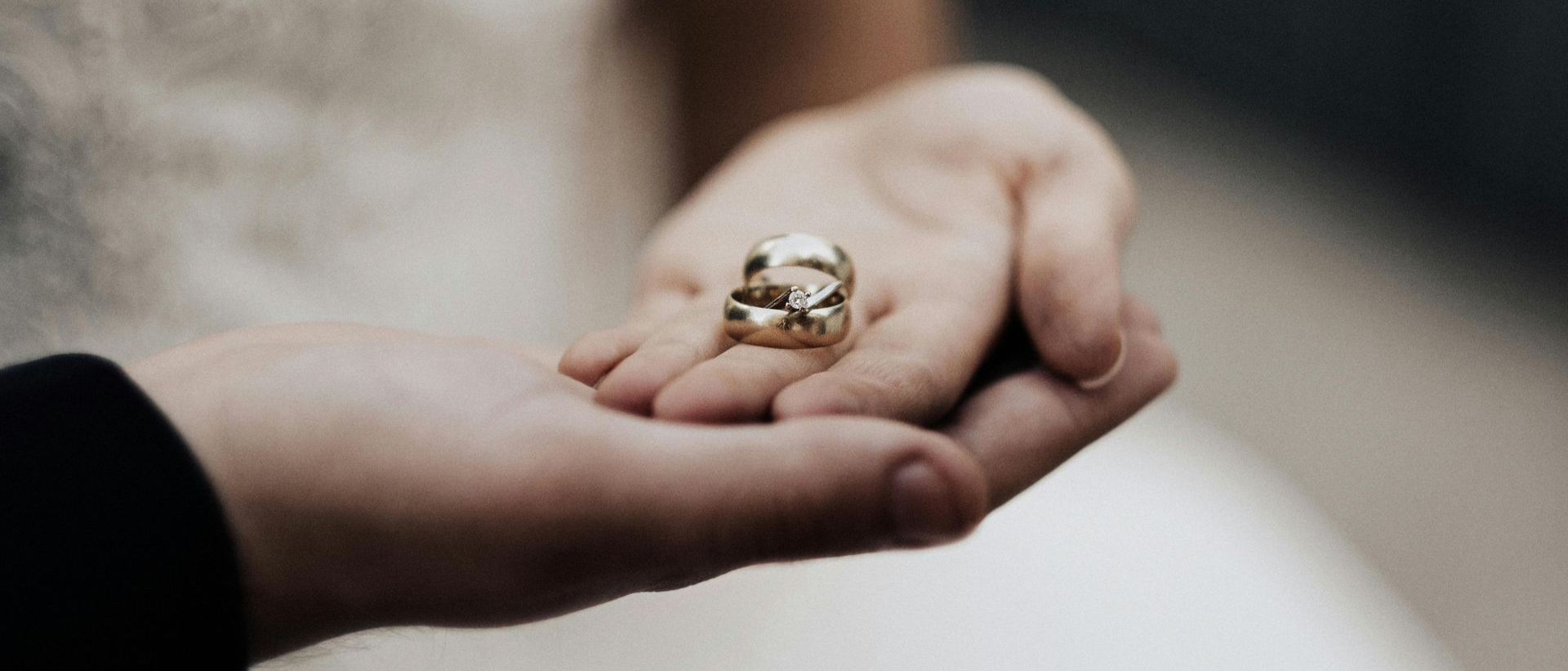 Gold mens wedding band and gold woman's wedding band shared with each other.