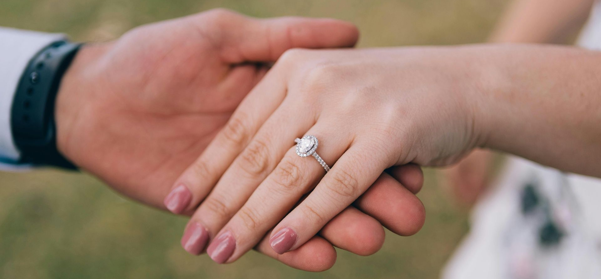 A man holding a woman's hand which shows a resized unique engagement ring in Wading River, NY.