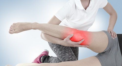 Terapeuta lavorando la zona del ginocchio segnata in rosso
