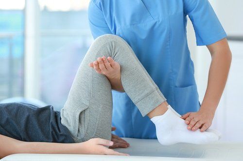 Terapeuta esercitando  le ginocchie del paziente
