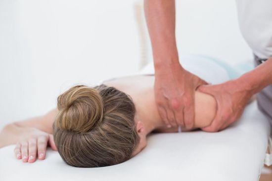 Terapeuta collocando le gambe della paziente sulla palla di pilates