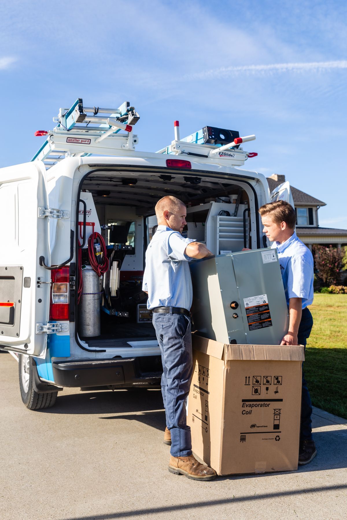 Two men are loading boxes into a van.