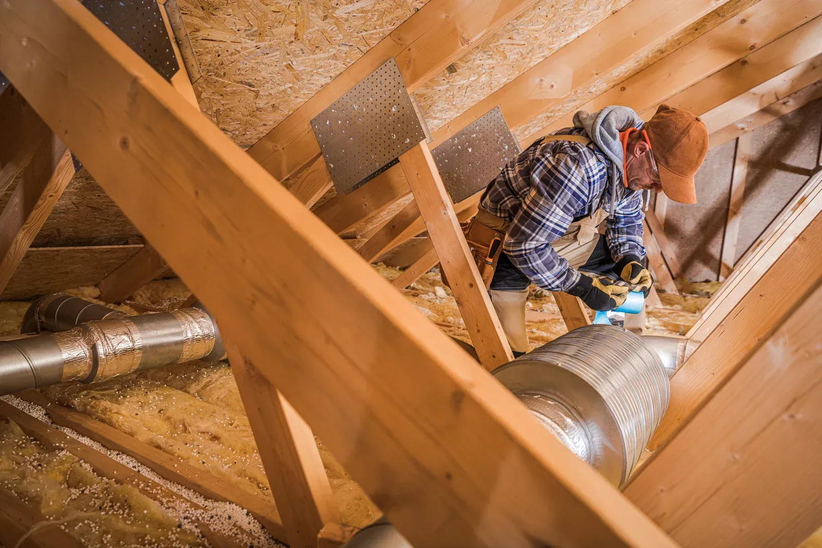 A man is working in the attic of a house.