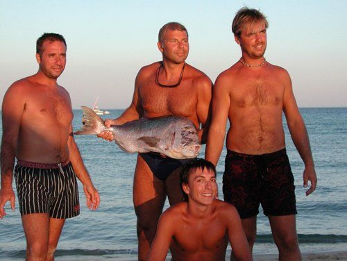 quattro amici con un pesce in mano