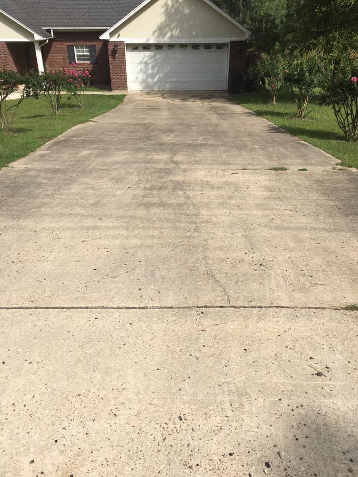 A driveway leading to a house with a white garage door