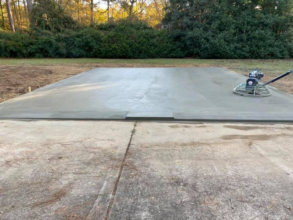 A machine is laying concrete on a concrete driveway.
