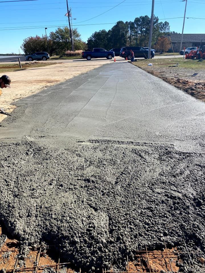 A concrete road is being built on a sunny day.
