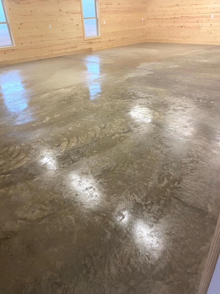 A shiny concrete floor in a room with wooden walls.