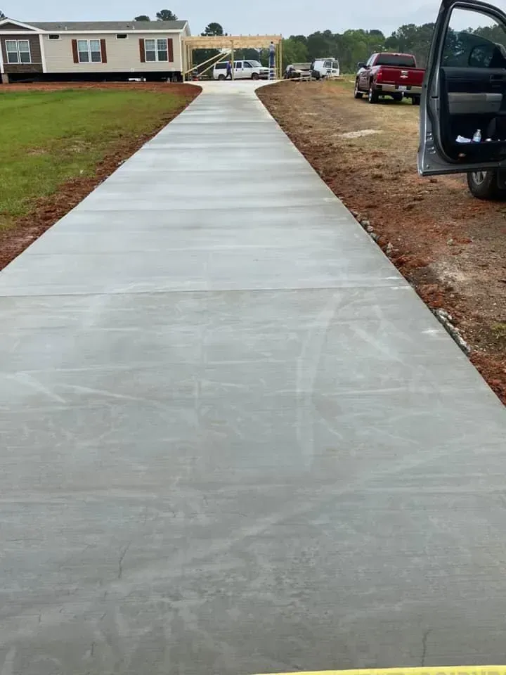 A concrete driveway leading to a mobile home.