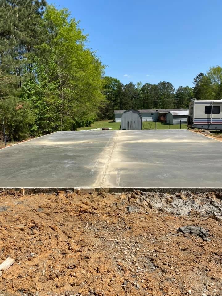 A concrete driveway is being built in the middle of a dirt field.