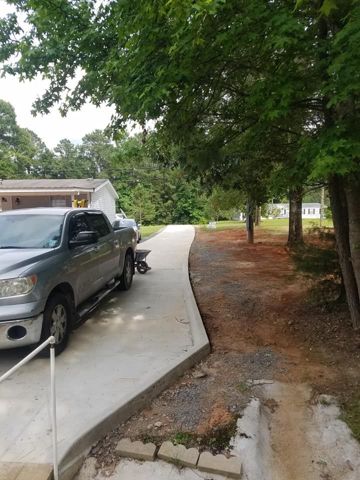 A truck is parked on the side of a concrete driveway.