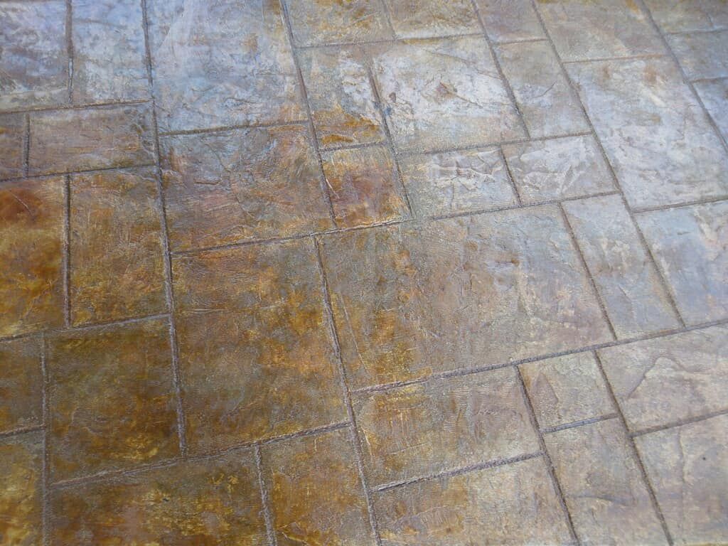 A close up of a tiled floor with a brick pattern.