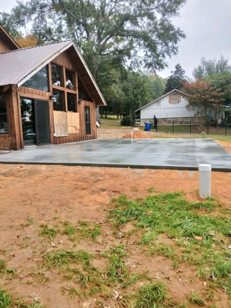A house is being built with a concrete driveway in front of it.