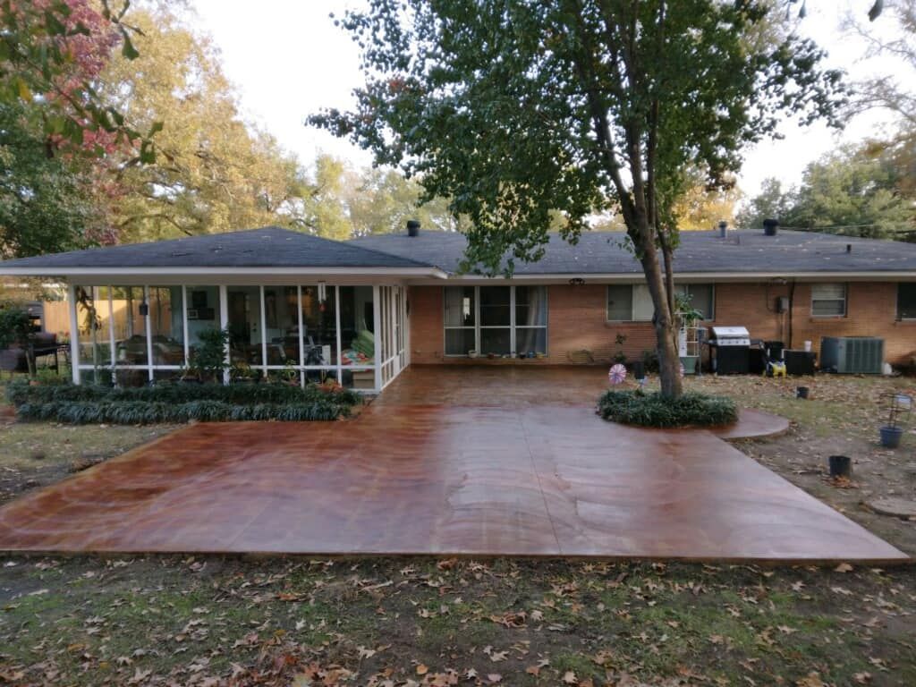 A brick house with a concrete driveway in front of it.