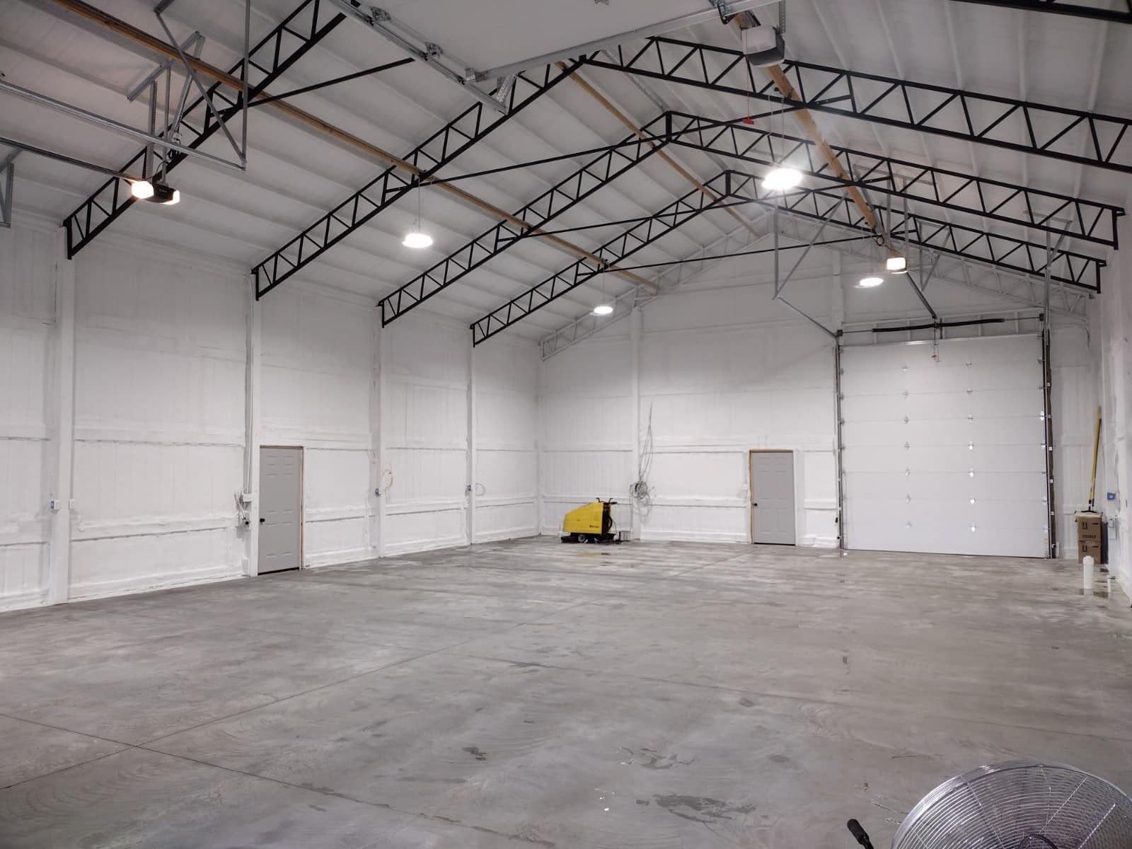 A large empty warehouse with white walls and a metal roof