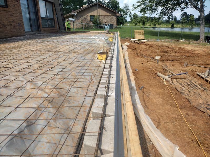A concrete patio is being built in front of a house.