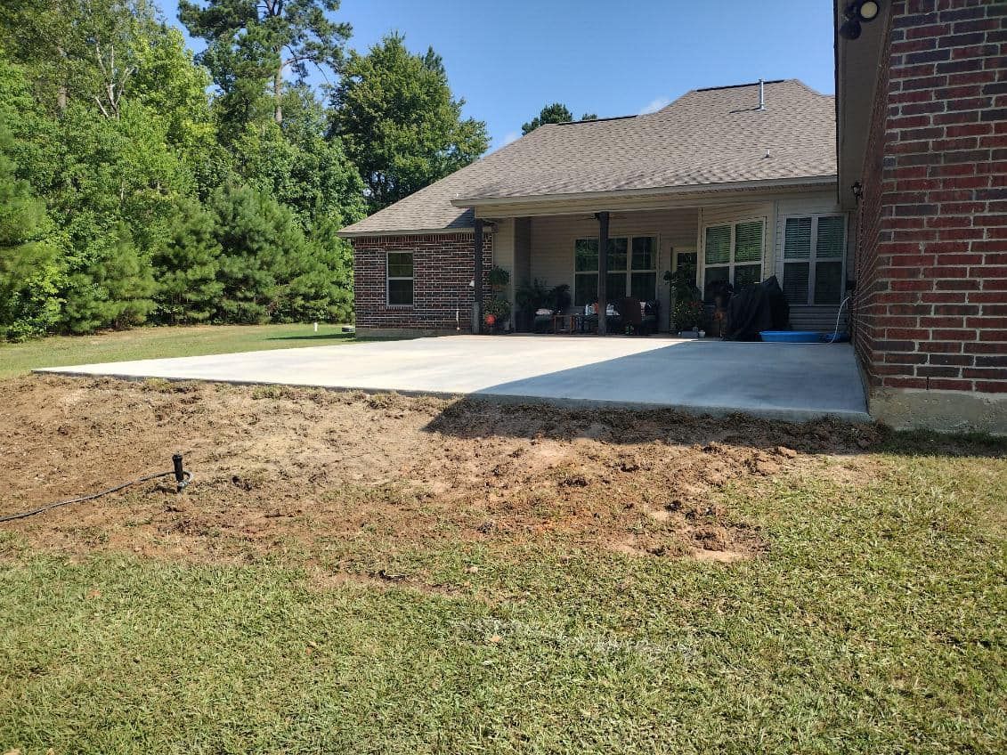 A brick house with a concrete driveway in front of it.
