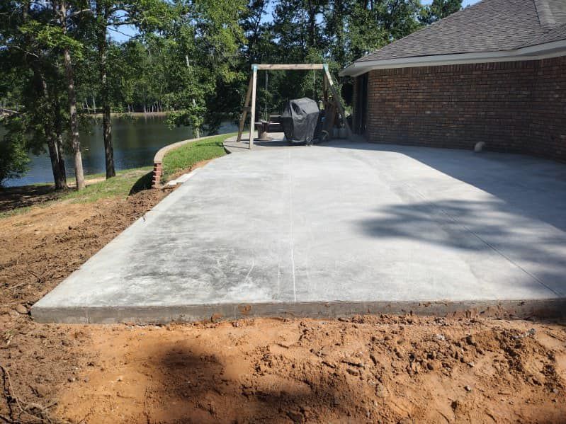 A concrete driveway is being built in front of a brick house.