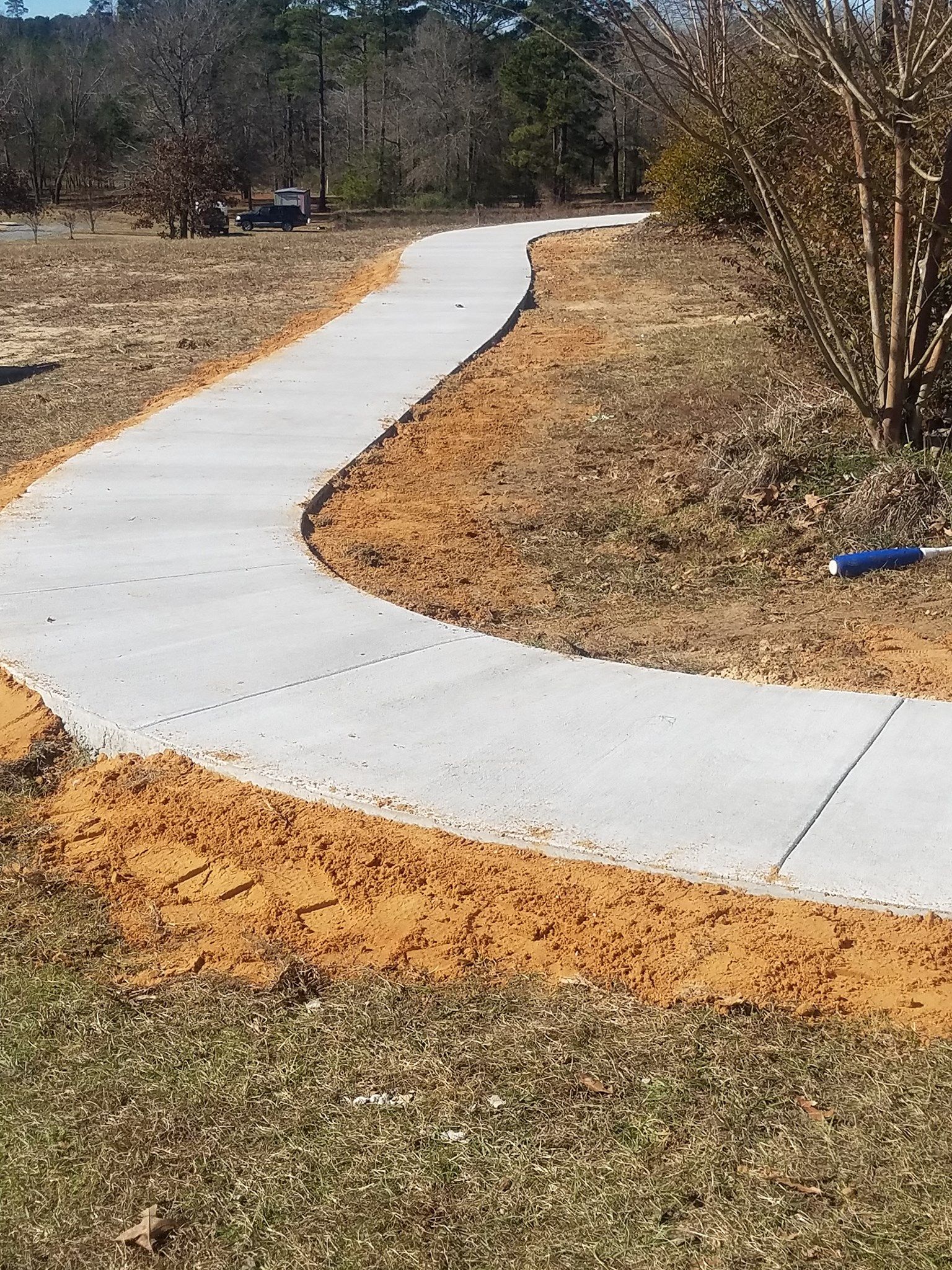 A concrete walkway is going through a field.