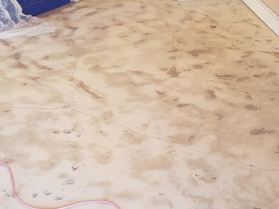 A dirty floor with a cord laying on it.