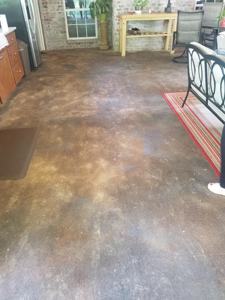 A person is standing on a concrete floor in a living room.