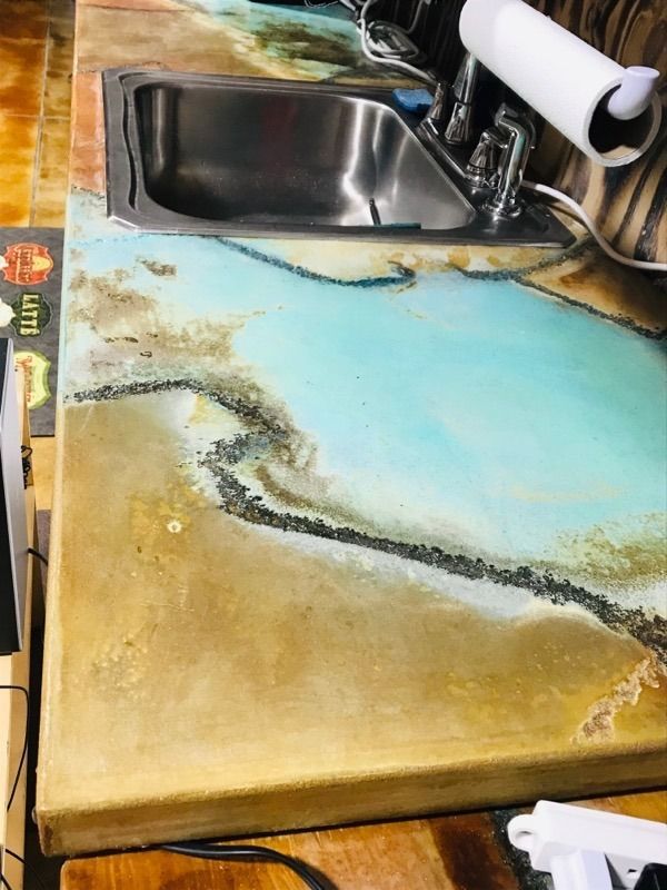 A kitchen counter with a sink and paper towels on it.