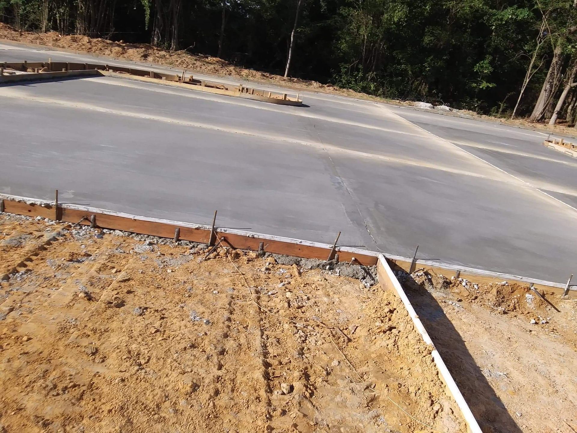 A concrete curb is being built on the side of a road