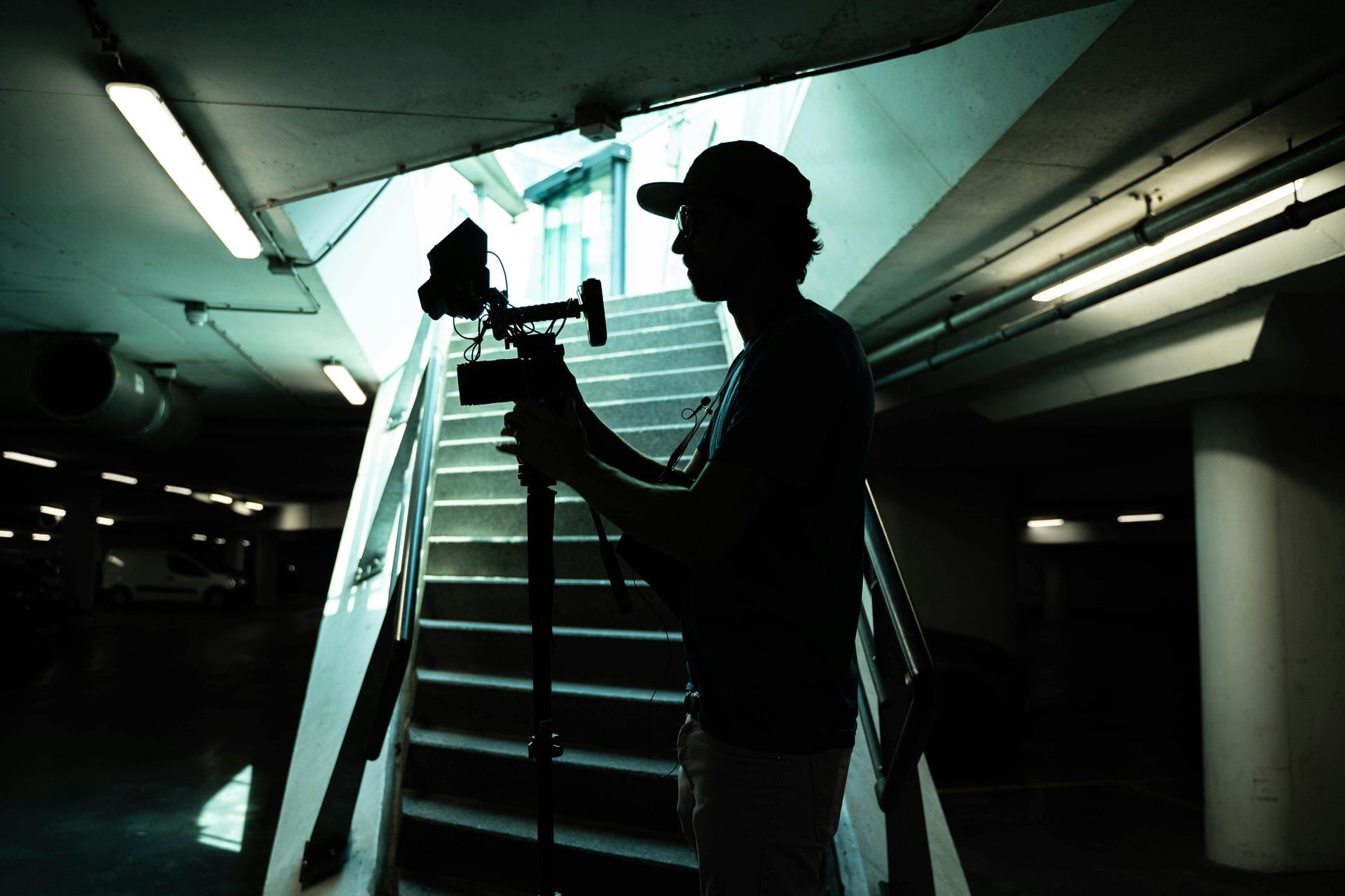 A silhouette of a man holding a camera in front of stairs