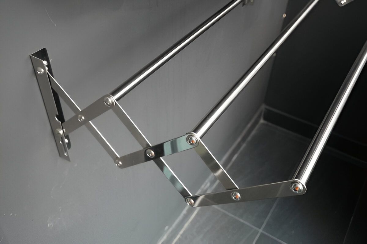 A Stainless Steel Clothes Rack is Attached to a Wall — South Coast Clothes Lines in Thirroul, NSW