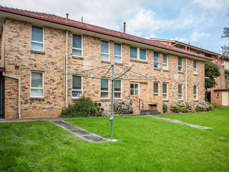 A Large Brick Building With a Lawn in Front of It — South Coast Clothes Lines in Southern Highlands, NSW