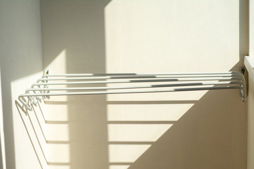 A Clothes Drying Rack is Hanging on a Wall Next to a Window — South Coast Clothes Lines in Southern Highlands, NSW