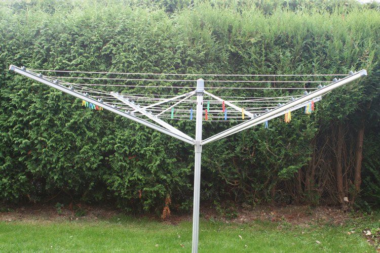 A Clothes Line is Sitting in the Grass in Front of a Hedge — South Coast Clothes Lines in Southern Highlands, NSW