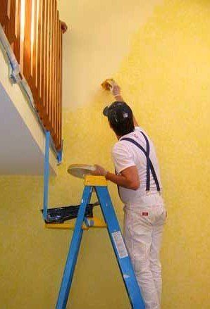 operaio mentre la pittura di parete in una casa