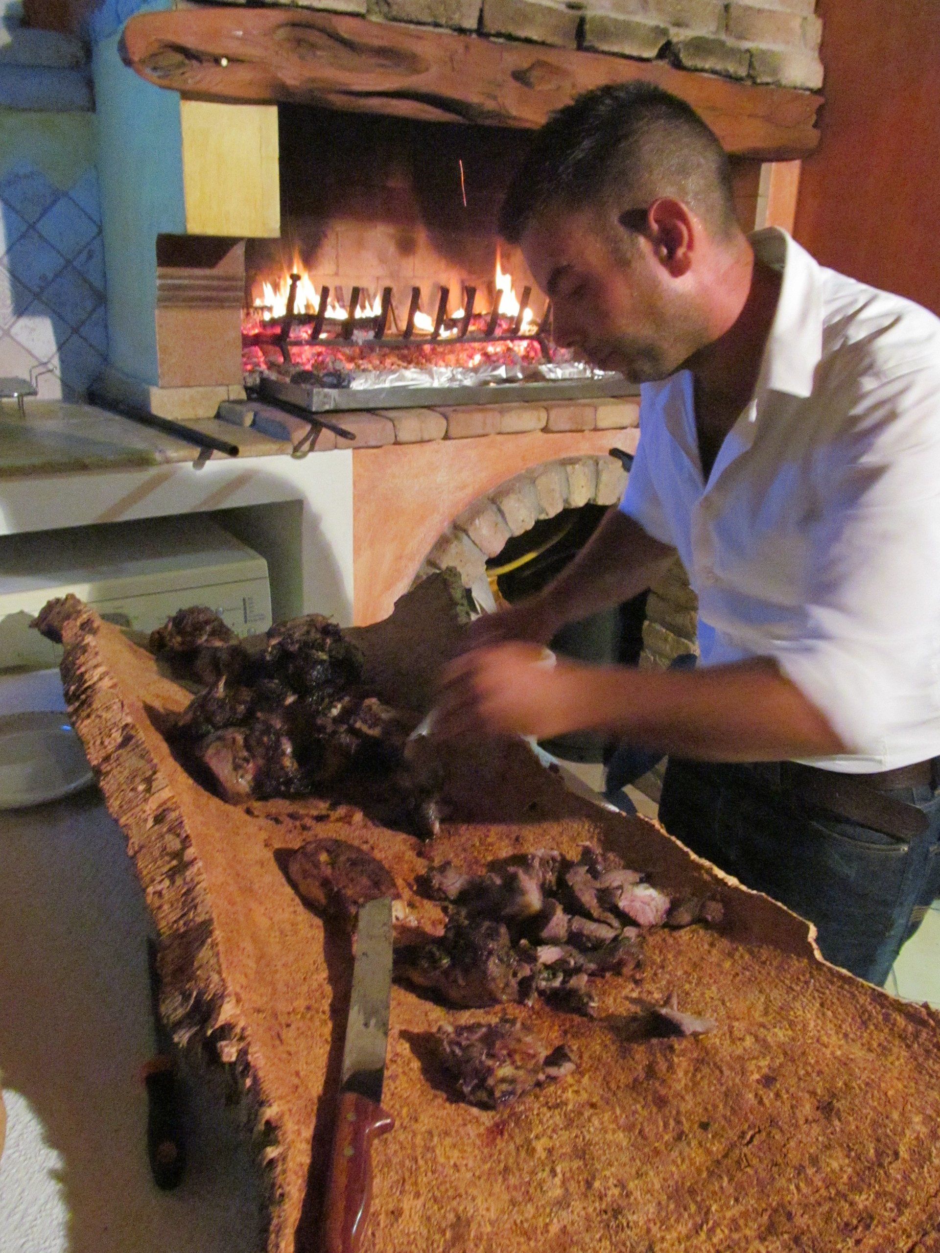 chef in una cucina mentre taglia carne