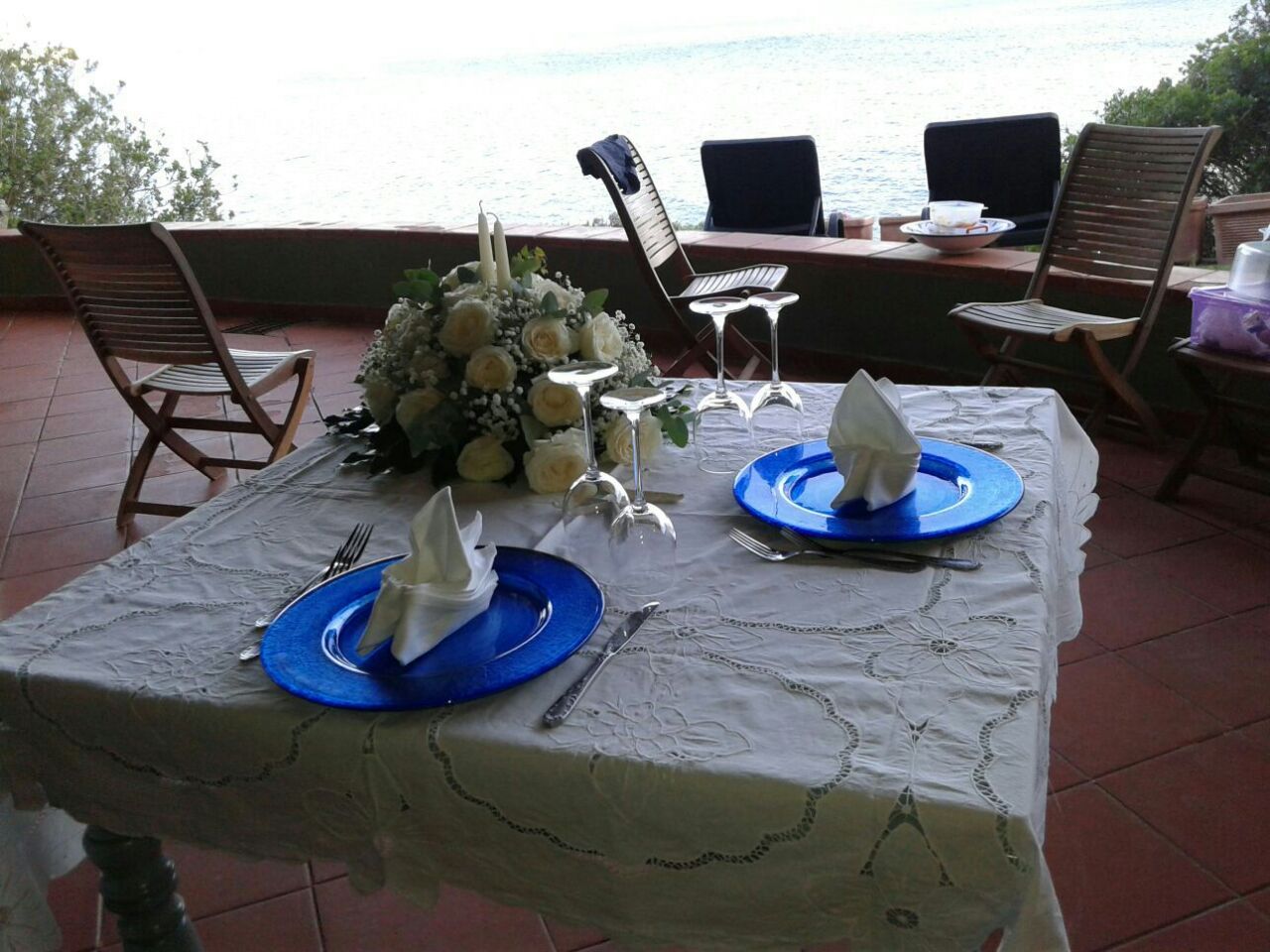 tavolo apparecchiato con un bouquet e due piatti-vista frontale