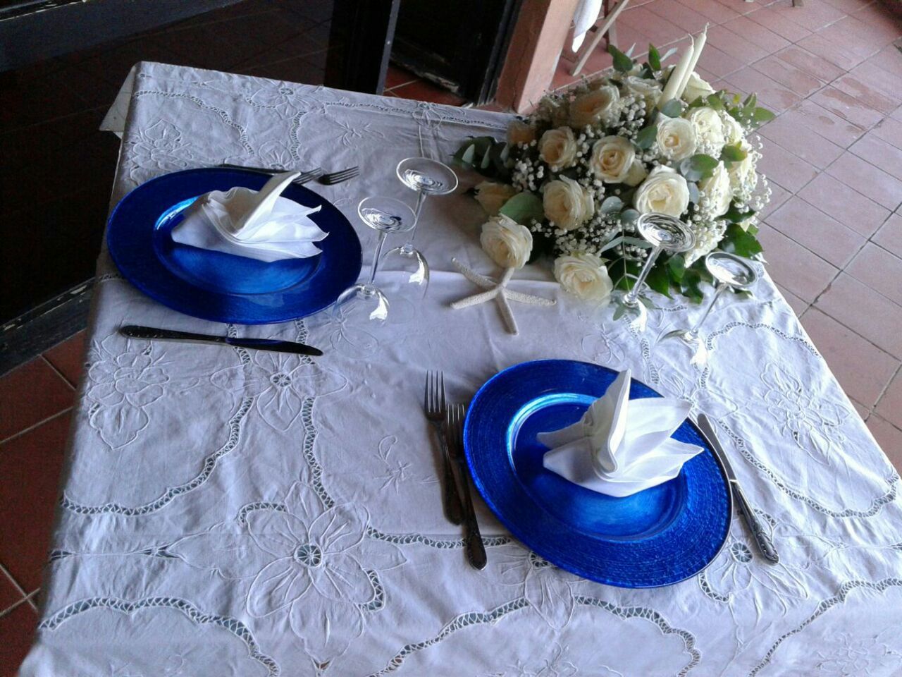 tavolo apparecchiato con un bouquet e due piatti