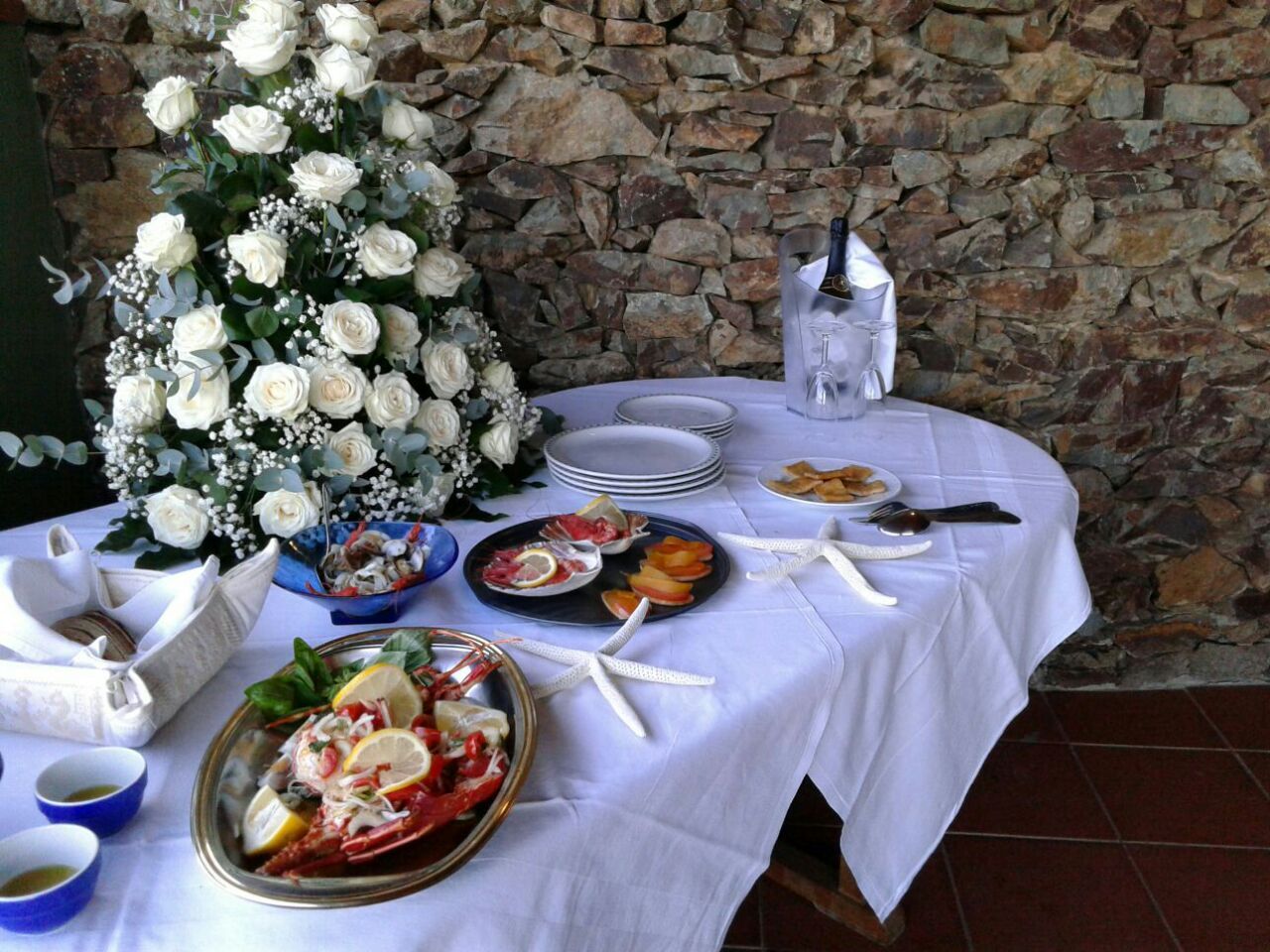 tavolo apparecchiate con bouquet di fiori bianche e insalata