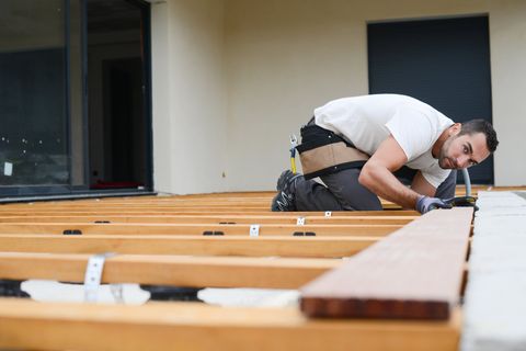 Lumber — Carpenter Installing a Wood Floor Outdoor Terrace in Oaklyn, NJ