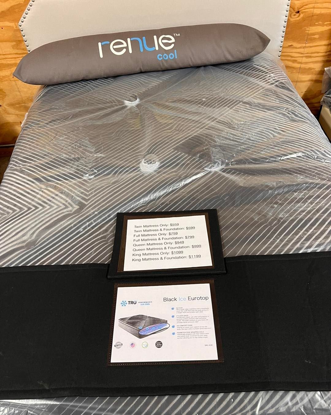 A bed with a pillow and two framed pictures on it.