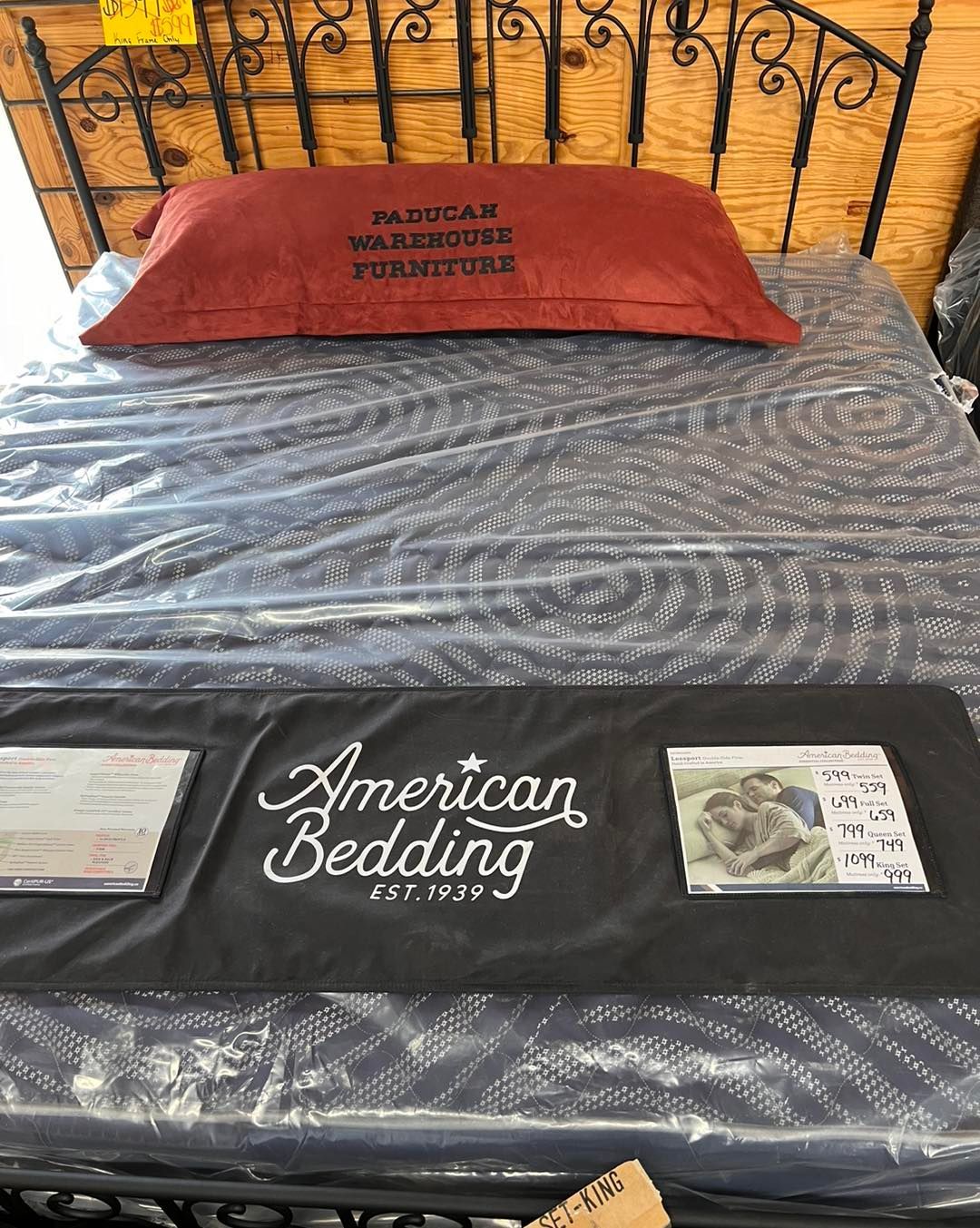 A bed with a pillow on top of it and a sign that says american bedding.