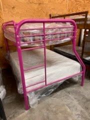 A pink bunk bed with a mattress on top of it.
